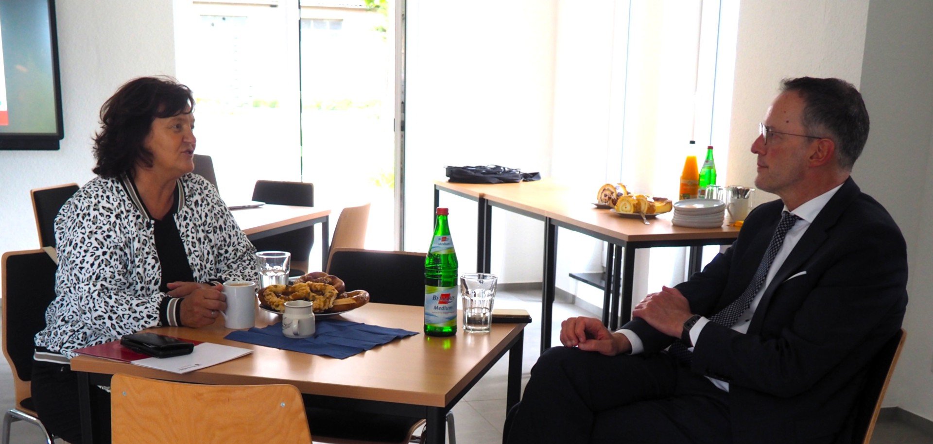 Frau und Mann sitzen sich an einem Tisch gegenüber