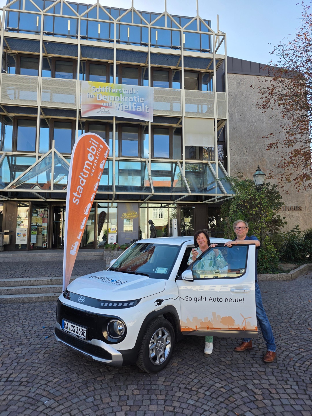 Eine Frau und ein Mann stehen an einem Auto