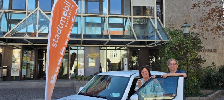 Eine Frau und ein Mann stehen an einem Auto