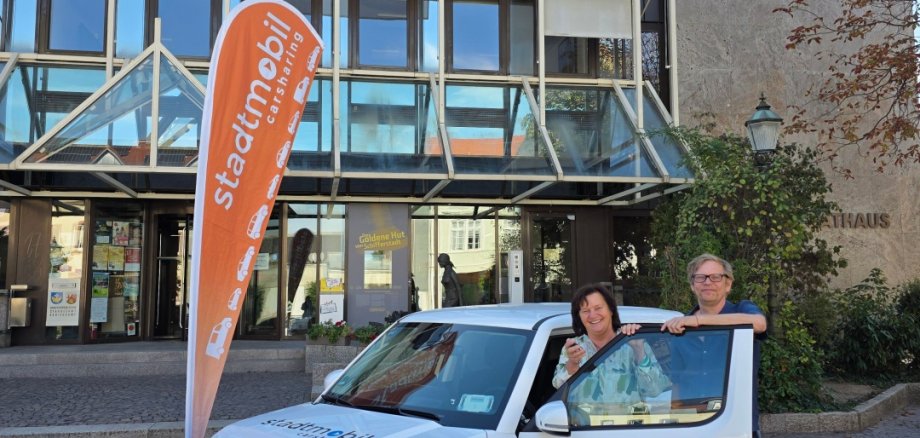 Eine Frau und ein Mann stehen an einem Auto