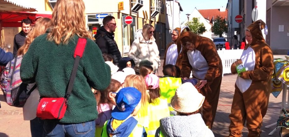 Kinder und Erwachsene bestaunen die als Osterhasen verkleidete Frauen