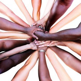 Hände verschiedener Menschen treffen sich in der Mitte des Bildes Eine Gruppe von vielfltigen Menschen bildet eine Einheit als Team