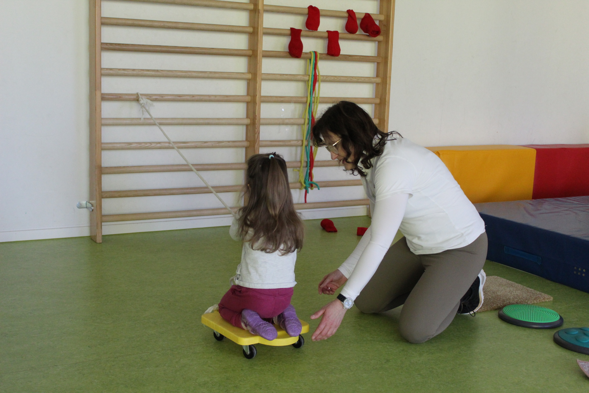 Kind und Betreuerin vor Sprossenwand