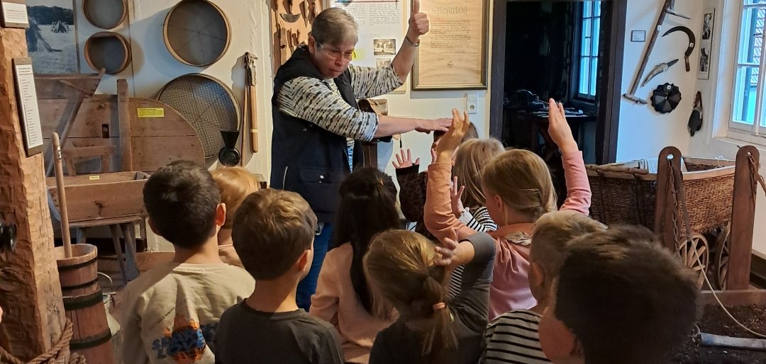 Frau, die einer Kindergruppe etwas erklärt