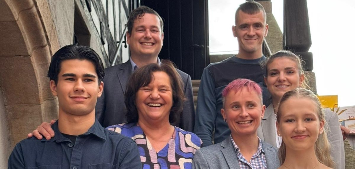 Mehrere Personen stehen auf dem Treppe zum Obergeschoss des Alten Rathauses