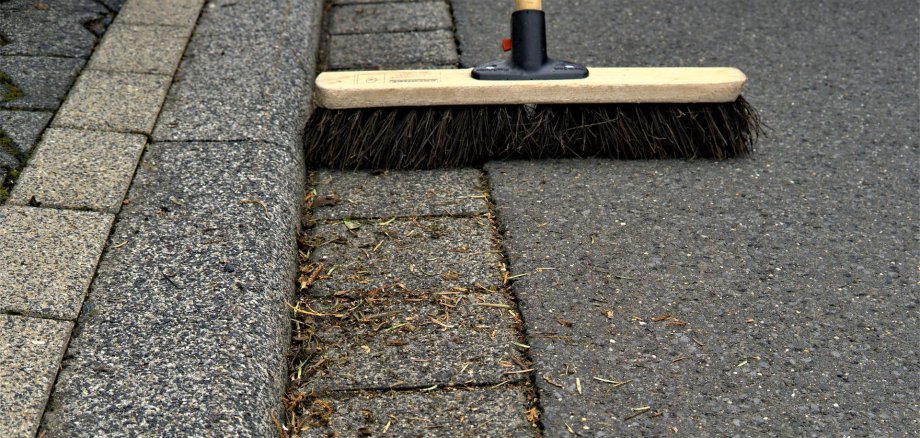 Besen auf der Straße beim Kehren