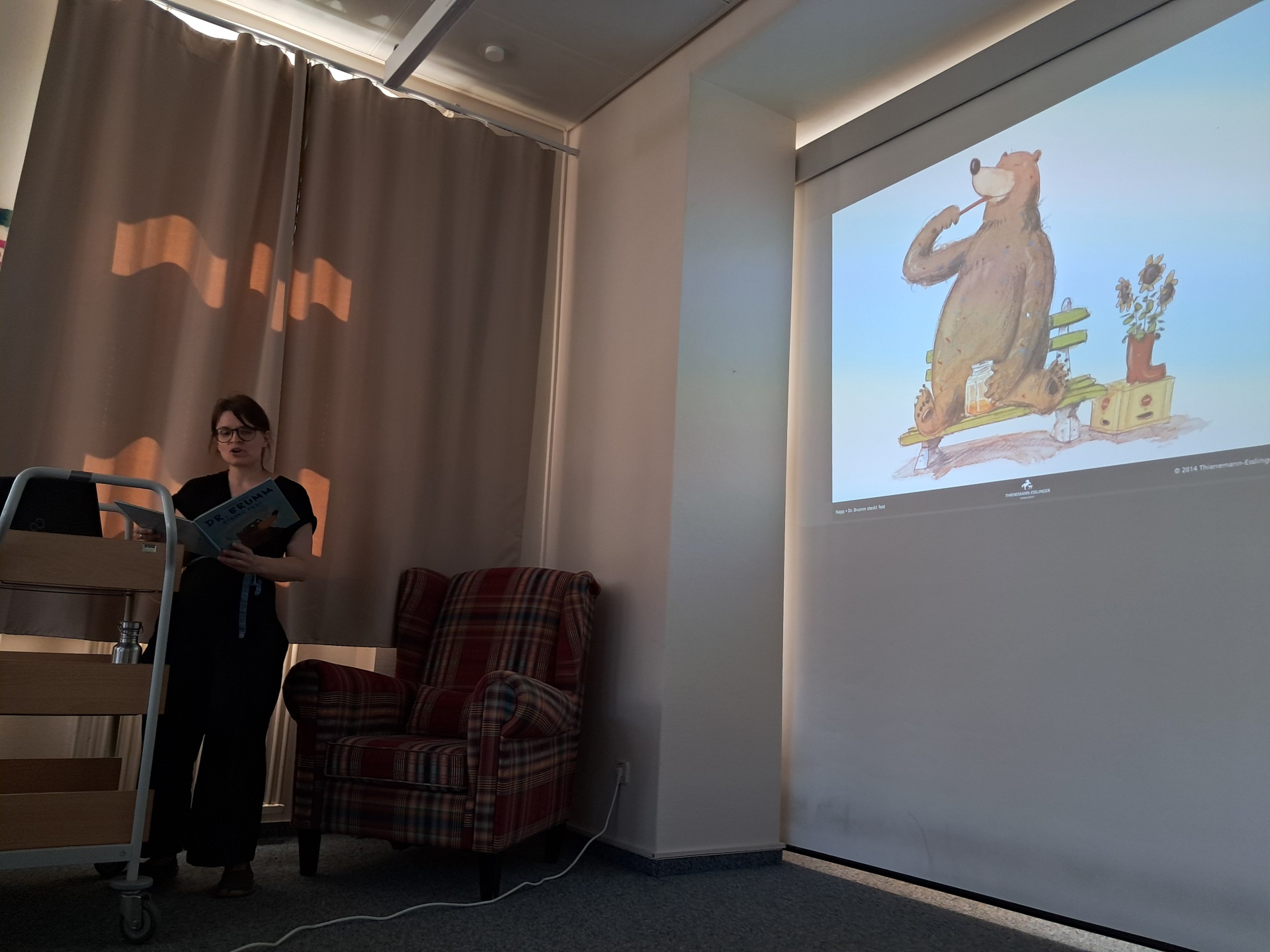 Frau vor einer Projektionswand mit einem gezeichneten Bär