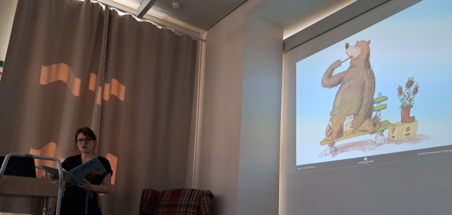 Frau vor einer Projektionswand mit einem gezeichneten Bär