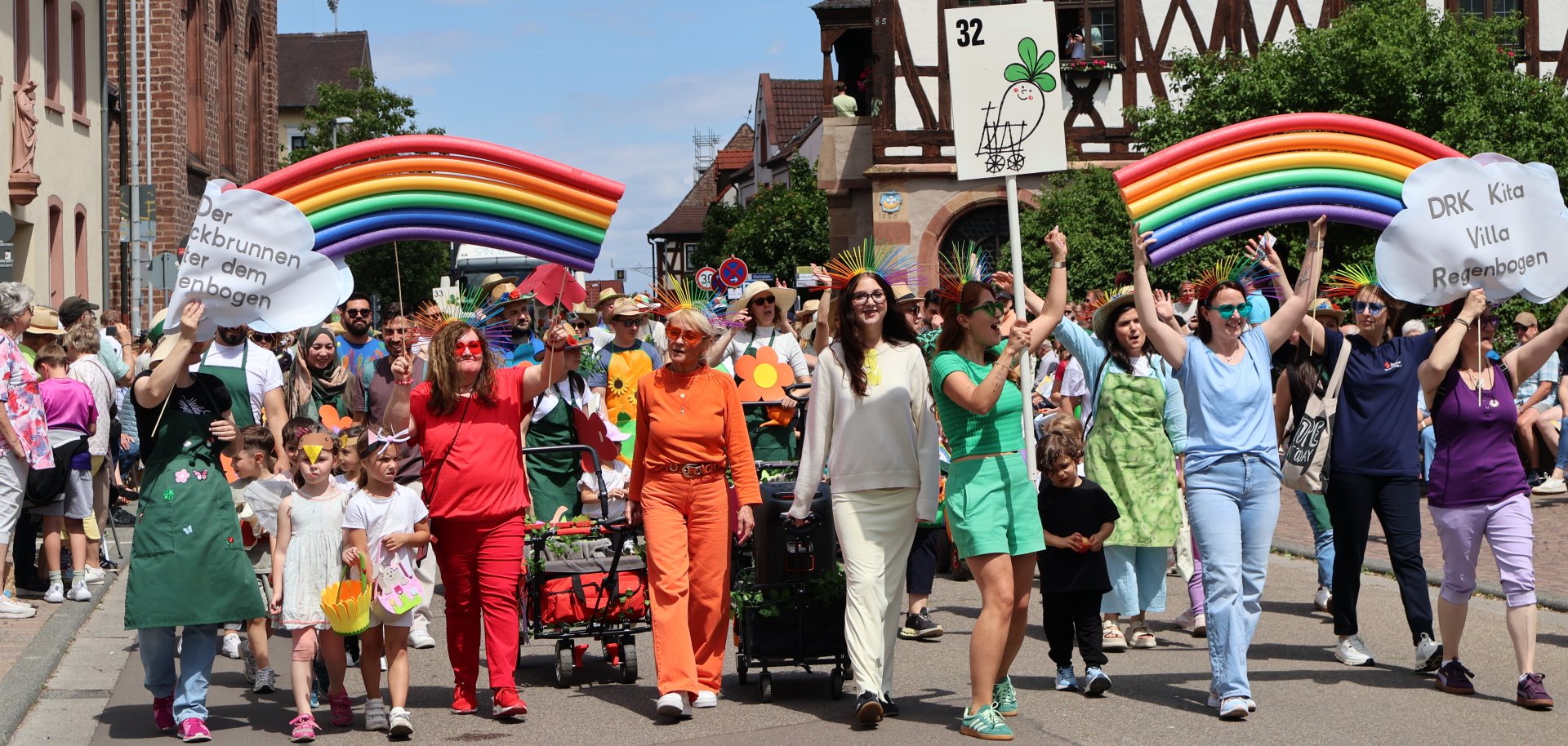 Fußgruppe in bunter Kleidung und selbst gebastelten Regenbögen
