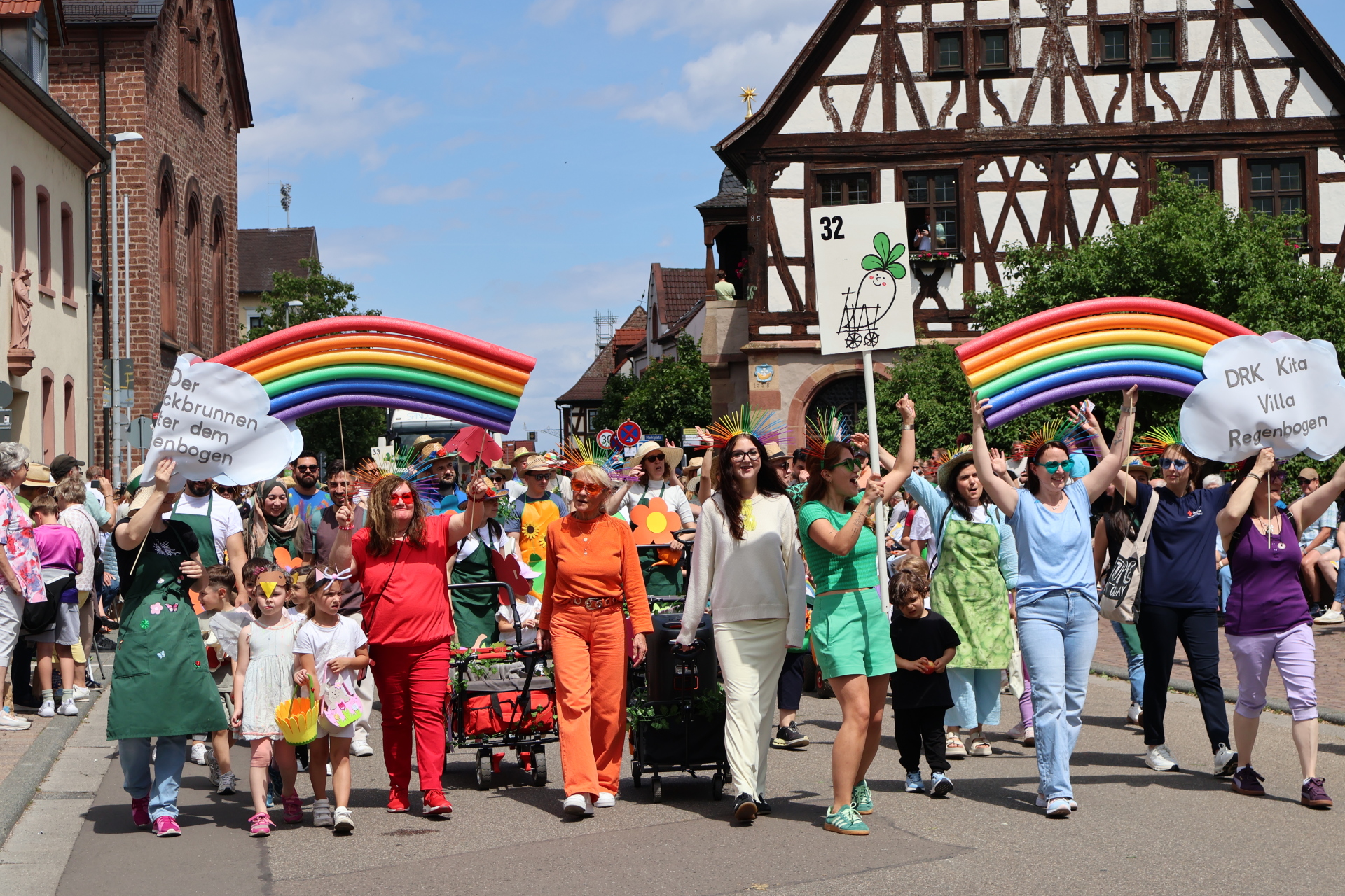 Fußgruppe in bunter Kleidung und selbst gebastelten Regenbögen