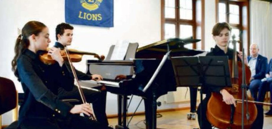 Jugendliche, die mit Streichinstrumenten Musik machen.