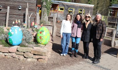 Vier Frauen stehen neben großen Ostereiern