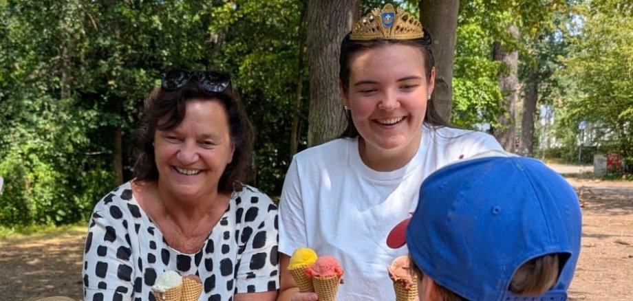 zwei Frauen mit Eistüten in der Hand und ein Kind von hinten 