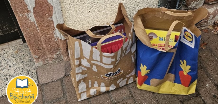 Tüten mit Büchern vor einem großen Kasten